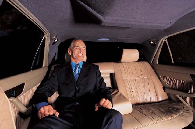 Senior Businessman Sitting in the Back Seat of a Limousine